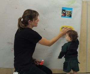 Los niños de Nursery trabajan atentamente haciendo su mural