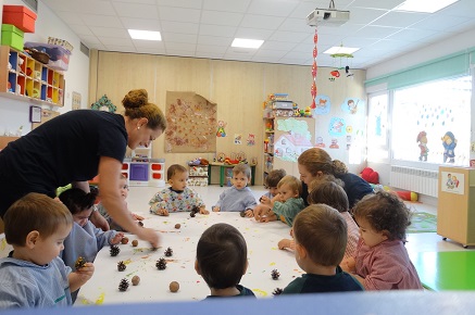 Los alumnos de Nursery 1 pintan con piñas y nueces para hacer un mural