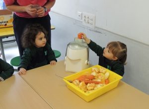Conociendo los alimentos, los alumnos de Nursery 1 hacen zumo de frutas. 