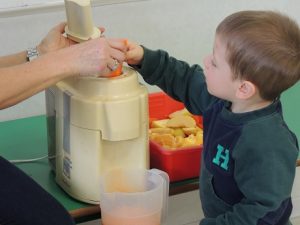 Conociendo los alimentos, los alumnos de Nursery 1 hacen zumo de frutas. 