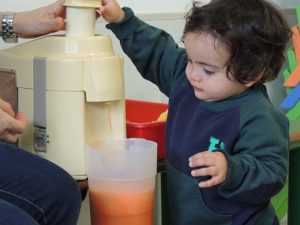 Conociendo los alimentos, los alumnos de Nursery 1 hacen zumo de frutas. 