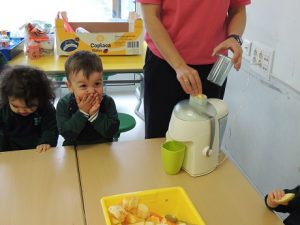 Conociendo los alimentos, los alumnos de Nursery 1 hacen zumo de frutas. 
