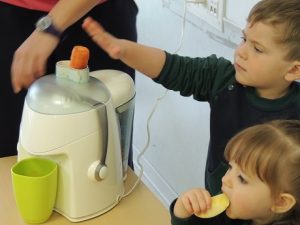 Conociendo los alimentos, los alumnos de Nursery 1 hacen zumo de frutas. 