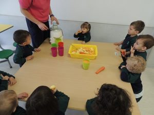 Conociendo los alimentos, los alumnos de Nursery 1 hacen zumo de frutas. 