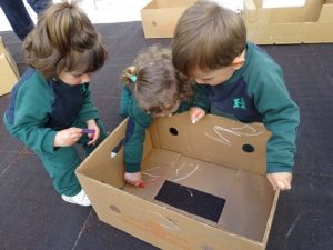 Taller de plástica con cajas en el patio.