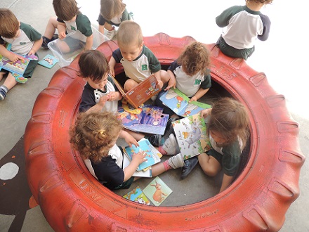 Alumnos de Nursery disfrutan en el patio viendo cuentos.