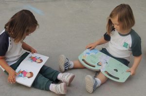 Alumnos de Nursery disfrutan en el patio viendo cuentos. 