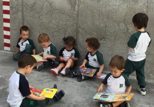 Alumnos de Nursery disfrutan en el patio viendo cuentos. 