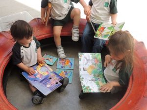 Alumnos de Nursery disfrutan en el patio viendo cuentos. 