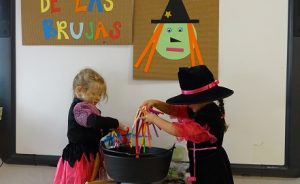 Alumnas de 2º de Infantil muestran a sus compañeros qué comen las brujas. 