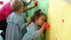 Los alumnos de Nursery 2 realizan un mural con los colores del otoño. 