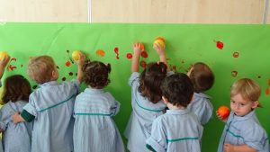 Los alumnos de Nursery 2 realizan un mural con los colores del otoño. 