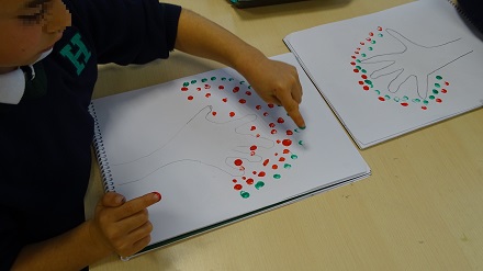 Pintando árboles usando mano y brazo como tronco en 1º de Primaria